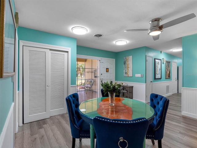 3944 49th Ave S, Saint Petersburg, FL 33711 - dining space with wainscoting, light wood-style flooring, and a ceiling fan