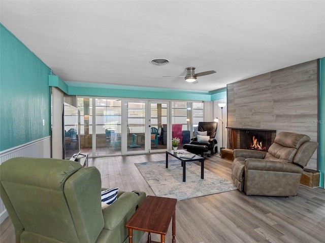 3944 49th Ave S, Saint Petersburg, FL 33711 - living area with wood finished floors, plenty of natural light, a tile fireplace, and a ceiling fan