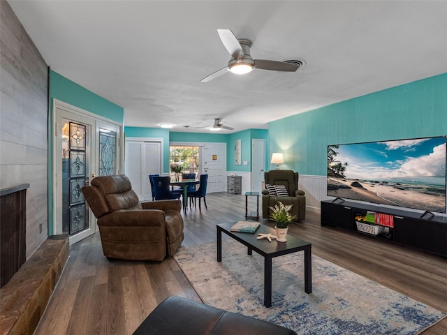 3944 49th Ave S, Saint Petersburg, FL 33711 - living room with ceiling fan, wood finished floors, a fireplace, and a wainscoted wall