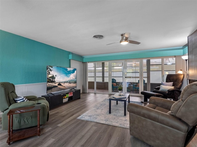 3944 49th Ave S, Saint Petersburg, FL 33711 - living area featuring an accent wall, a ceiling fan, wood finished floors, and wainscoting