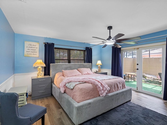 3944 49th Ave S, Saint Petersburg, FL 33711 - bedroom with wainscoting, access to exterior, wood finished floors, and ceiling fan