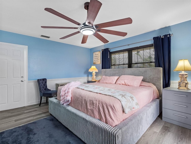 3944 49th Ave S, Saint Petersburg, FL 33711 - bedroom with wood finished floors, wainscoting, and ceiling fan