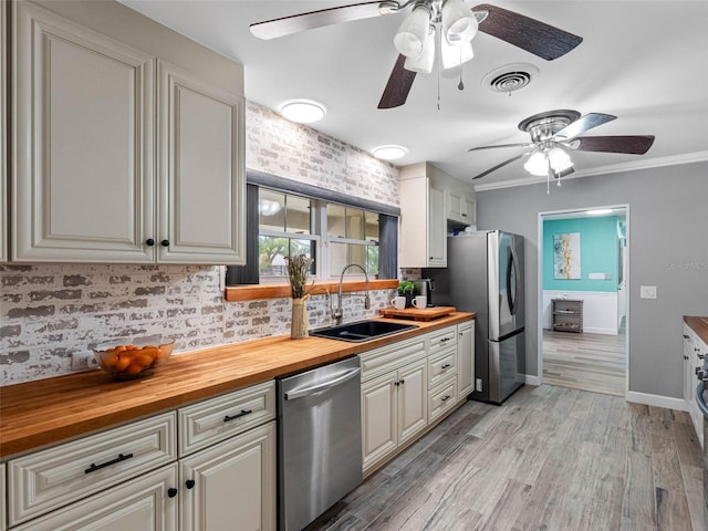 3944 49th Ave S, Saint Petersburg, FL 33711 - kitchen with appliances with stainless steel finishes, butcher block countertops, ceiling fan, decorative backsplash, and light wood-style flooring