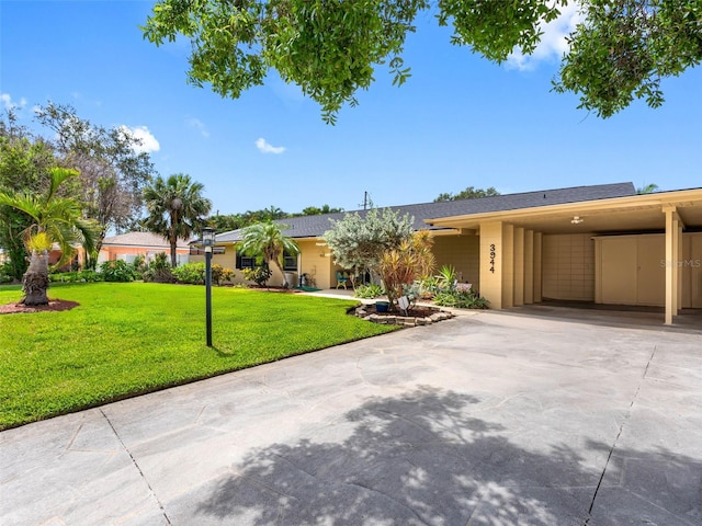 3944 49th Ave S, Saint Petersburg, FL 33711 - view of front facade with a front yard, driveway, and a carport