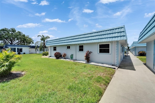 302 Andover Pl Unit G156, Sun City Center, FL 33573 - back of property featuring stucco siding, mansard roof, and a yard
