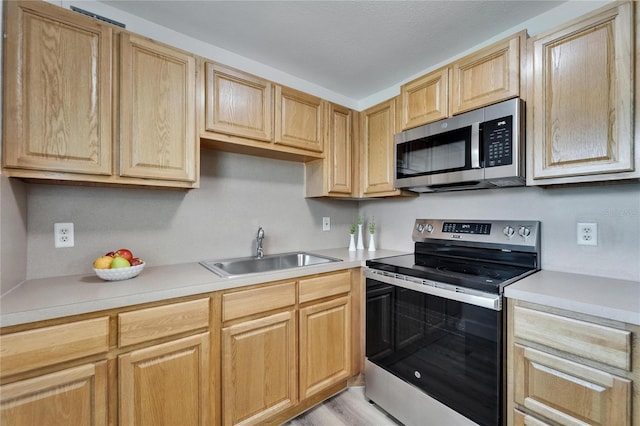 302 Andover Pl Unit G156, Sun City Center, FL 33573 - kitchen with stainless steel appliances, light brown cabinetry, light countertops, and light wood-type flooring