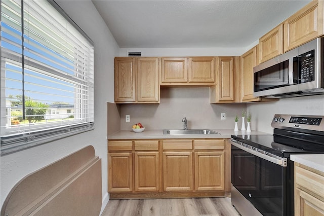 302 Andover Pl Unit G156, Sun City Center, FL 33573 - kitchen with appliances with stainless steel finishes, light wood-style floors, light countertops, and light brown cabinets