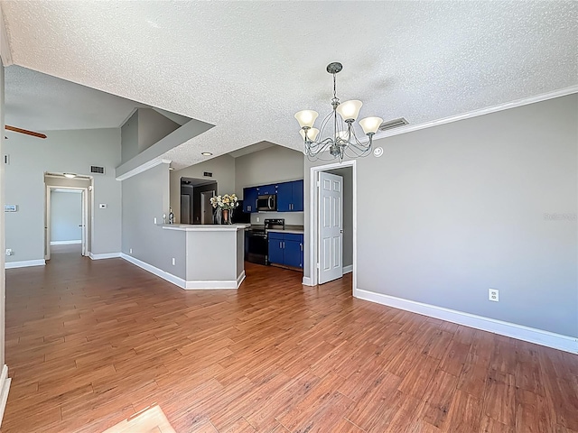 6001 Lemon Tree Ct, Tampa, FL 33625 - kitchen with blue cabinets, appliances with stainless steel finishes, a chandelier, a textured ceiling, and a peninsula