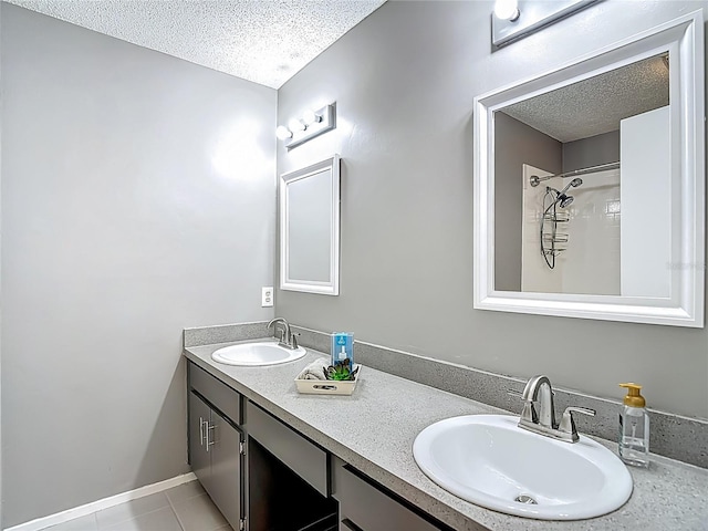 6001 Lemon Tree Ct, Tampa, FL 33625 - bathroom featuring a textured ceiling, double vanity, tile patterned floors, and a shower