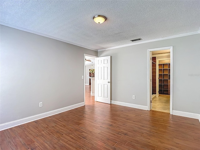 6001 Lemon Tree Ct, Tampa, FL 33625 - unfurnished bedroom featuring a textured ceiling, ornamental molding, wood finished floors, a spacious closet, and a closet