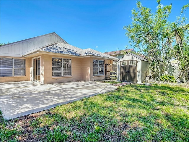 6001 Lemon Tree Ct, Tampa, FL 33625 - rear view of property featuring a storage unit, a patio, a shingled roof, and concrete block siding