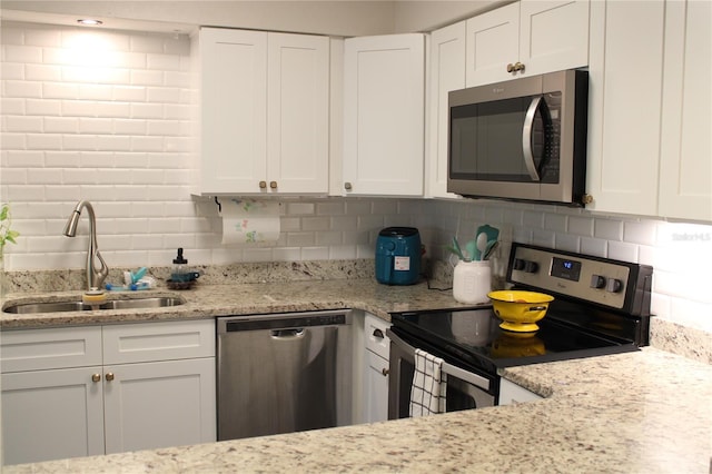 2101 Sunset Point Rd Unit 2304, Clearwater, FL 33765 - kitchen featuring appliances with stainless steel finishes, tasteful backsplash, white cabinets, and light stone counters