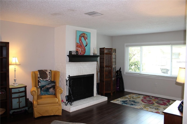 2101 Sunset Point Rd Unit 2304, Clearwater, FL 33765 - living area featuring wood finished floors, a fireplace, and a textured ceiling