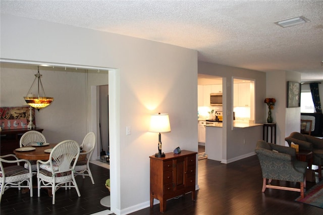 2101 Sunset Point Rd Unit 2304, Clearwater, FL 33765 - dining room with dark wood-type flooring and a textured ceiling