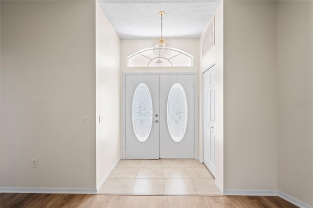 11412 Alden Ct, Hudson, FL 34667 - foyer featuring a textured ceiling, a chandelier, and light tile patterned floors