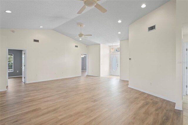 11412 Alden Ct, Hudson, FL 34667 - unfurnished living room with a ceiling fan, lofted ceiling, light wood-type flooring, recessed lighting, and stacked washer / dryer