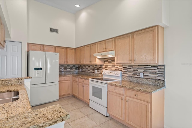 11412 Alden Ct, Hudson, FL 34667 - kitchen featuring white appliances, under cabinet range hood, light brown cabinets, a high ceiling, and light tile patterned floors