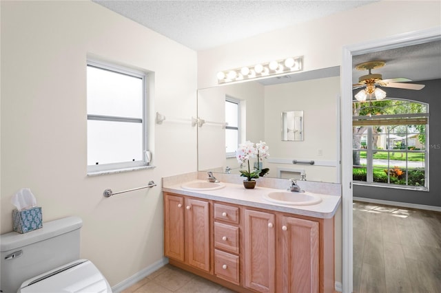 11412 Alden Ct, Hudson, FL 34667 - bathroom featuring double vanity, ceiling fan, and a textured ceiling