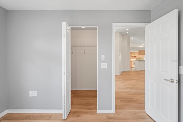 11412 Alden Ct, Hudson, FL 34667 - unfurnished bedroom with a closet, a walk in closet, light wood-type flooring, and recessed lighting