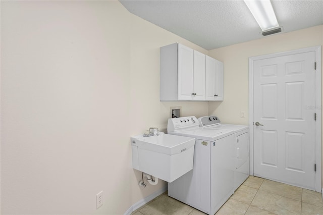 11412 Alden Ct, Hudson, FL 34667 - washroom with washer and dryer, cabinet space, light tile patterned flooring, and a textured ceiling