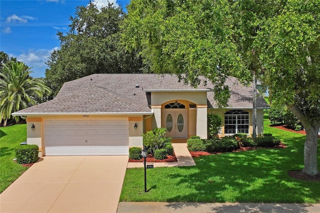 11412 Alden Ct, Hudson, FL 34667 - view of front of home featuring stucco siding, an attached garage, a front yard, driveway, and a shingled roof