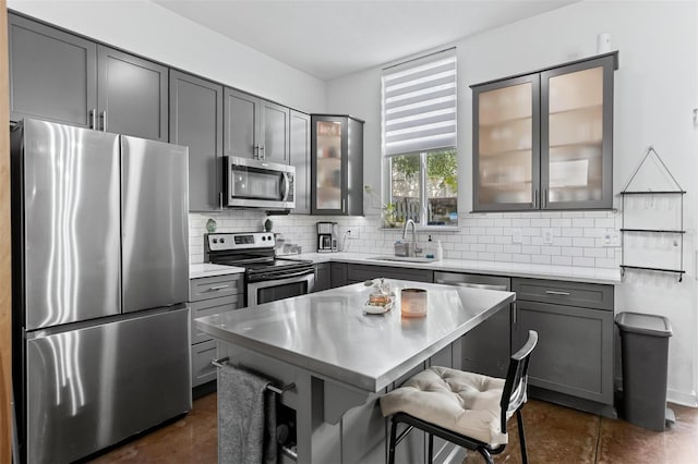 851 3rd Ave N, Saint Petersburg, FL 33701 - kitchen with appliances with stainless steel finishes, gray cabinets, light countertops, backsplash, and a kitchen bar