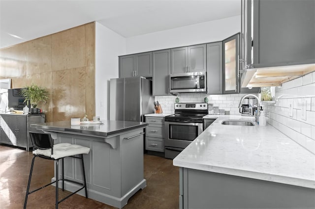 851 3rd Ave N, Saint Petersburg, FL 33701 - kitchen with stainless steel appliances, gray cabinets, finished concrete flooring, and tasteful backsplash