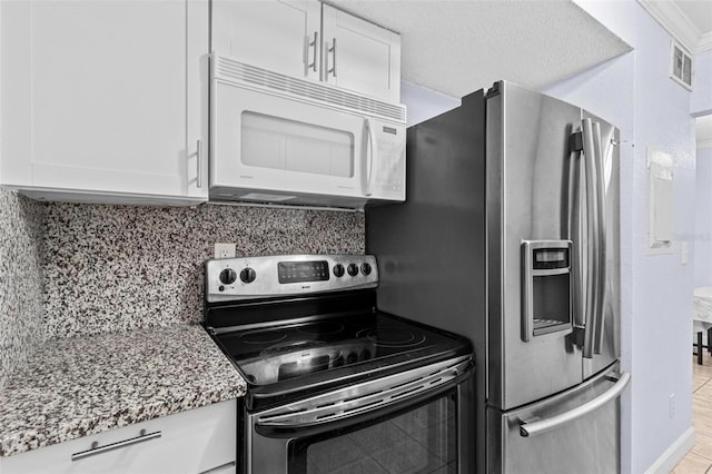 1813 Bough Ave Unit B, Clearwater, FL 33760 - kitchen featuring stainless steel appliances, white cabinets, light stone countertops, and tasteful backsplash