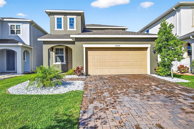 33854 Floating Heart Ct, Wesley Chapel, FL 33545 - traditional-style home featuring stucco siding, decorative driveway, a garage, and a shingled roof
