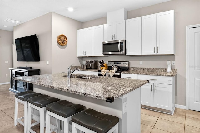 33854 Floating Heart Ct, Wesley Chapel, FL 33545 - kitchen featuring stainless steel appliances, light tile patterned flooring, white cabinets, and light stone countertops