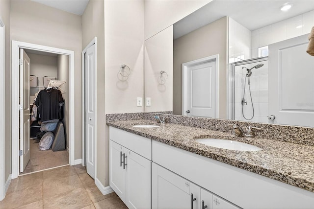 33854 Floating Heart Ct, Wesley Chapel, FL 33545 - bathroom featuring double vanity, a spacious closet, a shower stall, and tile patterned floors