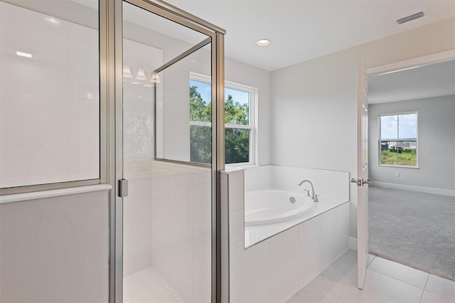 12758 Oak Hill Way, Parrish, FL 34219 - bathroom featuring healthy amount of natural light, a bath, a stall shower, tile patterned flooring, and recessed lighting