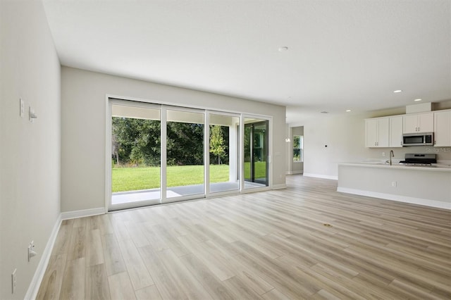 12758 Oak Hill Way, Parrish, FL 34219 - unfurnished living room with light wood finished floors and recessed lighting