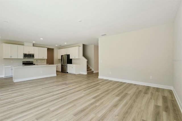 12758 Oak Hill Way, Parrish, FL 34219 - unfurnished living room featuring light wood-style flooring, recessed lighting, and stairway
