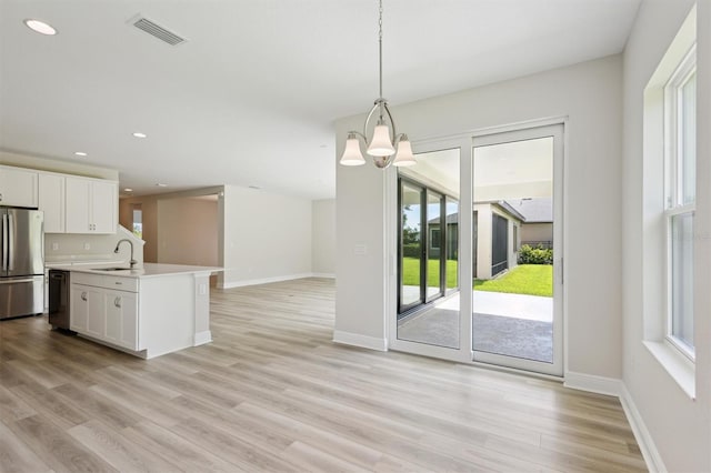 12758 Oak Hill Way, Parrish, FL 34219 - kitchen featuring freestanding refrigerator, open floor plan, white cabinetry, light wood-type flooring, and light countertops