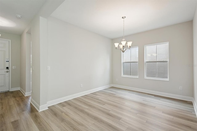 12758 Oak Hill Way, Parrish, FL 34219 - empty room with a chandelier, light wood finished floors, and a smoke detector