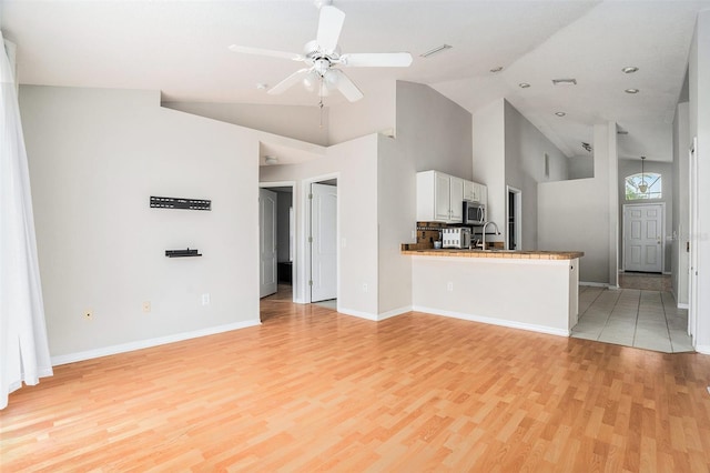 10039 Creek Bluff Dr, Riverview, FL 33578 - unfurnished living room with high vaulted ceiling, light wood-style floors, and a ceiling fan