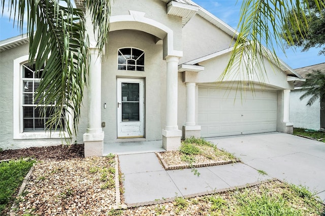 10039 Creek Bluff Dr, Riverview, FL 33578 - doorway to property featuring stucco siding, a garage, and driveway
