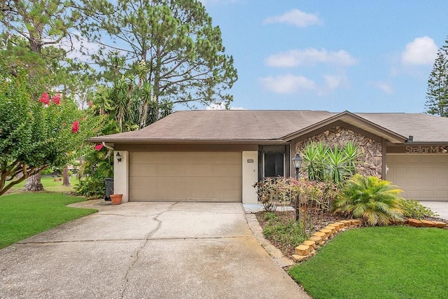 3902 Shoreside Cir, Tampa, FL 33624 - view of front facade featuring an attached garage, a front lawn, concrete driveway, stone siding, and stucco siding