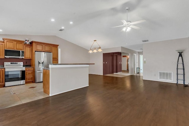 3902 Shoreside Cir, Tampa, FL 33624 - kitchen with stainless steel appliances, lofted ceiling, open floor plan, a ceiling fan, and brown cabinets