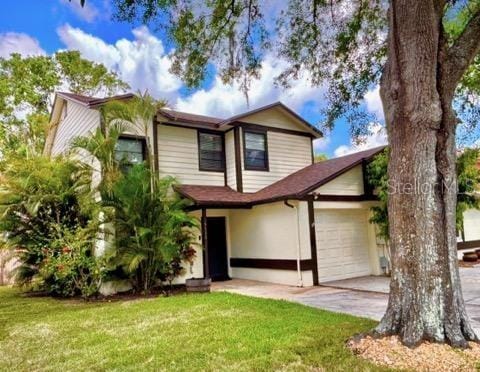 5110 Corvette Dr, Tampa, FL 33624 - view of front facade with an attached garage, a front yard, and concrete driveway