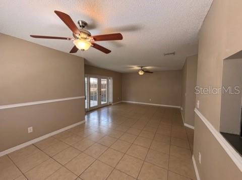 5110 Corvette Dr, Tampa, FL 33624 - empty room with a ceiling fan, light tile patterned floors, a textured ceiling, and french doors