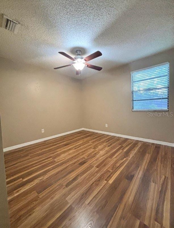 5110 Corvette Dr, Tampa, FL 33624 - empty room featuring ceiling fan, a textured ceiling, and wood finished floors