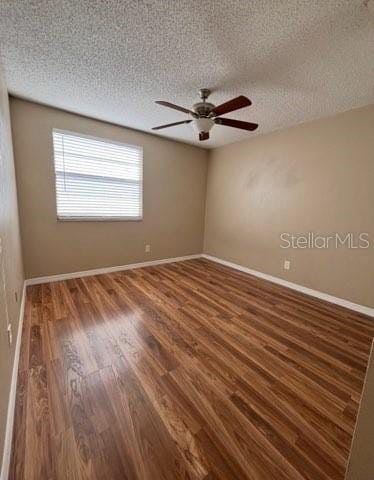 5110 Corvette Dr, Tampa, FL 33624 - empty room featuring wood finished floors, a textured ceiling, and a ceiling fan
