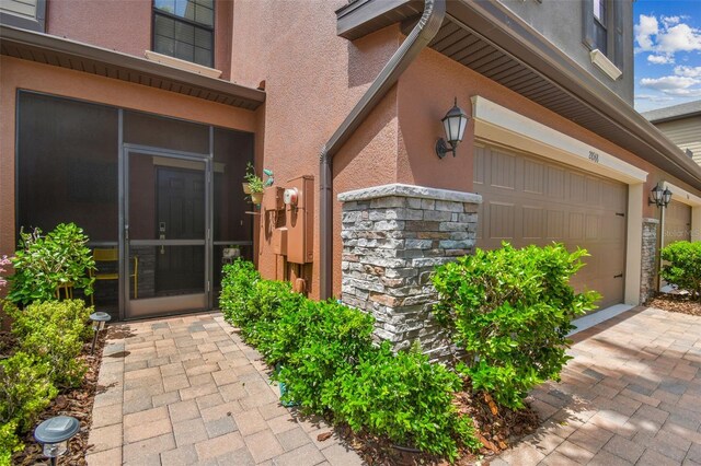 28568 Tranquil Lake Cir, Wesley Chapel, FL 33543 - property entrance with stucco siding, stone siding, and a garage