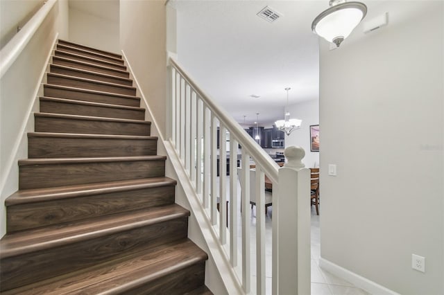 28568 Tranquil Lake Cir, Wesley Chapel, FL 33543 - staircase featuring a chandelier and tile patterned flooring