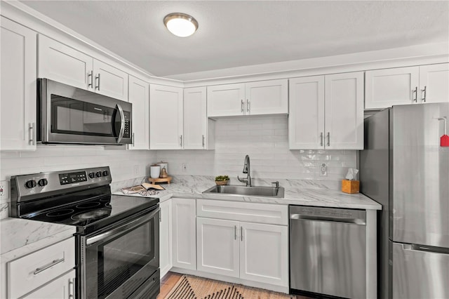 1743 Fulton Ave, Clearwater, FL 33755 - kitchen featuring appliances with stainless steel finishes, tasteful backsplash, white cabinetry, and light stone counters
