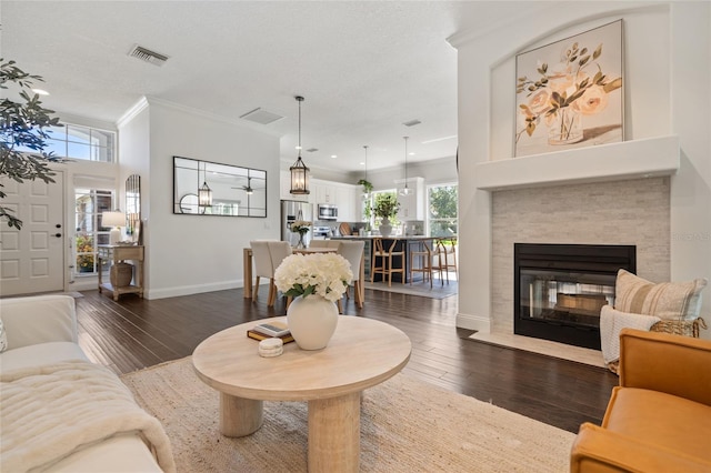 2182 Trevor Rd, Palm Harbor, FL 34683 - living room with dark wood finished floors, crown molding, plenty of natural light, a fireplace with flush hearth, and recessed lighting