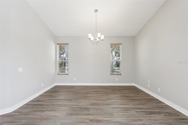19113 Golden Cacoon Pl, Lutz, FL 33558 - empty room with a chandelier, wood finished floors, and vaulted ceiling