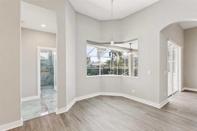 19113 Golden Cacoon Pl, Lutz, FL 33558 - unfurnished room featuring arched walkways, wood finished floors, and a ceiling fan